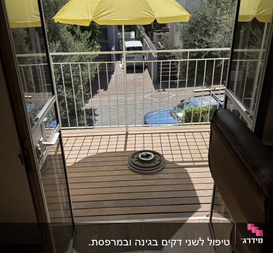 מרפסת עץ עם שמשייה צהובה ומעמד מתכת